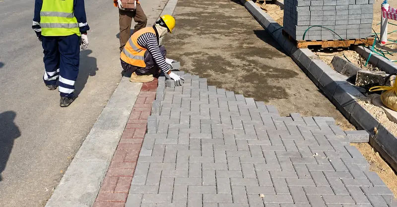 Concrete paver installation along a pedestrian route.