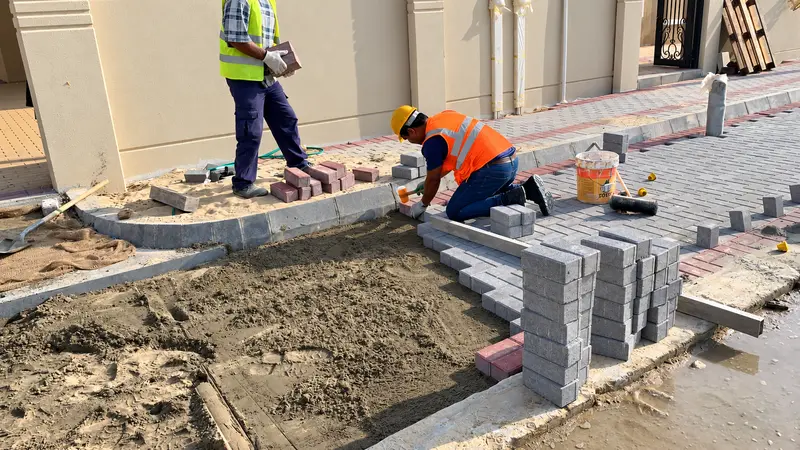 Bedding preparation and individual paver placement.