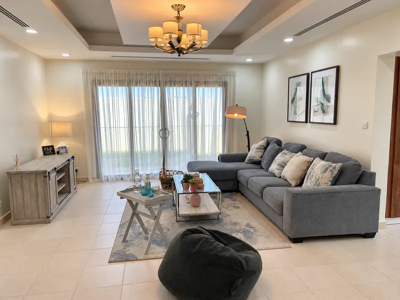 Residential lounge with layered lighting and a grey sectional sofa.