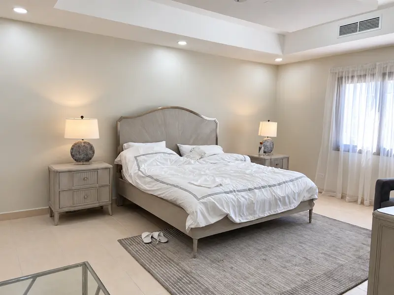 Bedroom furnishings, bedside lighting and sheer curtains.