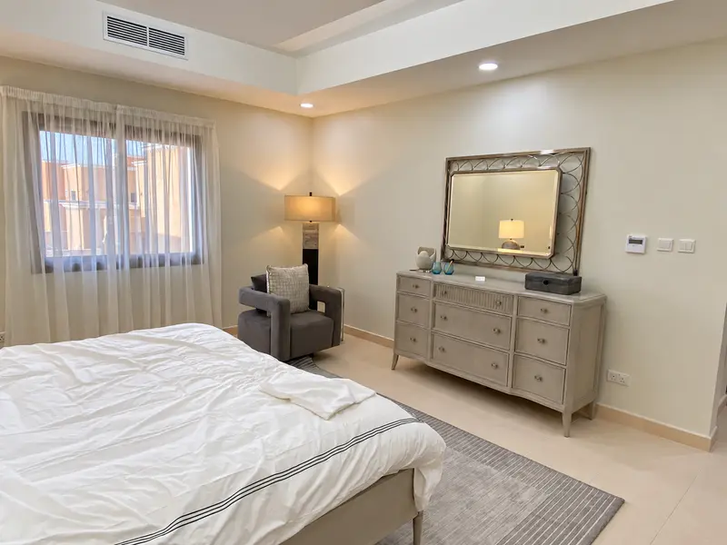 Bedroom storage, framed mirror and coordinated accent lighting.