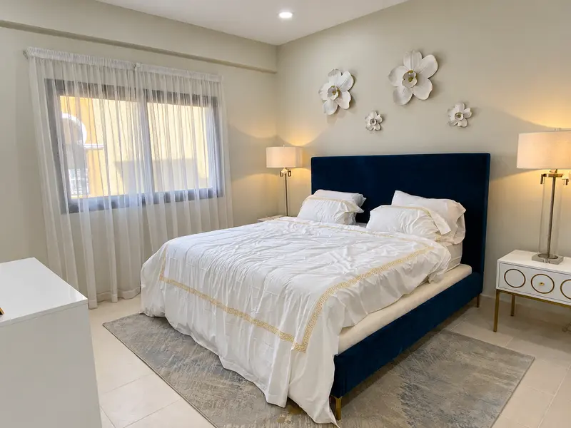 Upholstered headboard, bedside tables and decorative wall features.