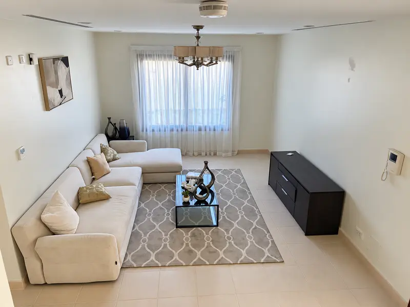 Residential lounge layout with a corner sofa and glass coffee table.