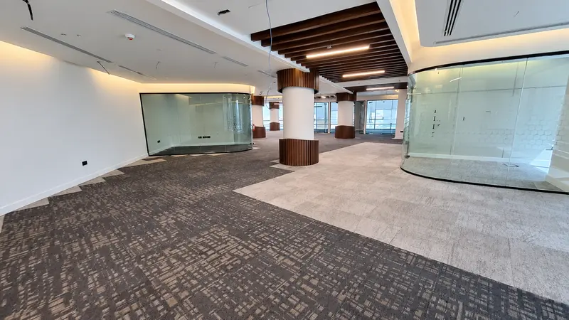 Office interior with curved glass partitions and coordinated floor finishes.